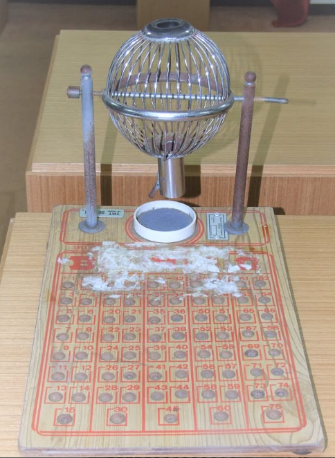 Globo de sorteio prateado com uma tábua de madeira na parte de baixo