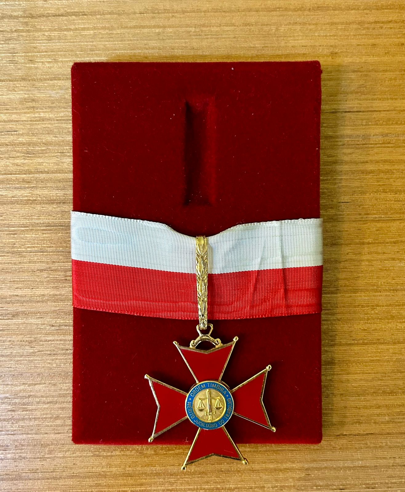 Medalha apoiada em base na cor vermelha