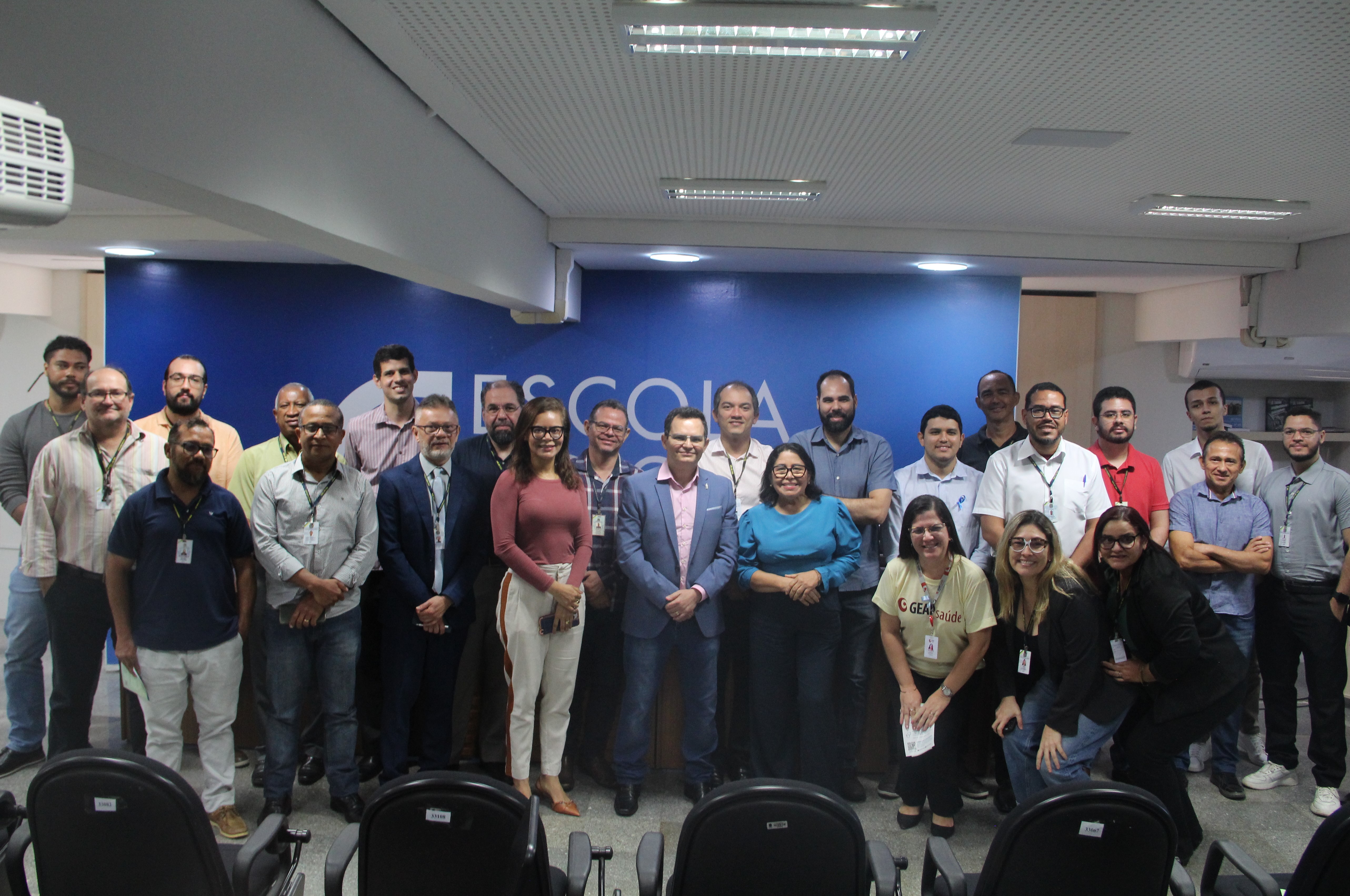 Foto mostra servidores e o médico Antônio Minervino em pé no auditório da EJUD16