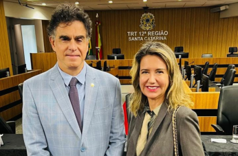 Foto mostra um homem e um mulher, em pé, um posicionado ao lado do outro.