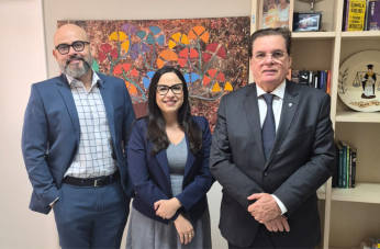 Foto de dois homens e uma mulher de pé e sorrindo.