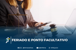 Foto parcial de uma mulher de cabelos claros, usando blazer marrom, segurando um celular na mão esquerda e um martelo de juiz na mão direita, em frente a um notebook aberto. Ao seu lado, vê-se uma balança, representando a Justiça. Em primeiro plano, uma tarja azul com o texto branco FERIADO E PONTO FACULTATIVO ao lado da logomarca do TRT-16. Abaixo do texto, os ícones e endereços do TRT-16 nas redes sociais.