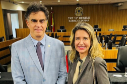 Foto mostra um homem e um mulher, em pé, um posicionado ao lado do outro.