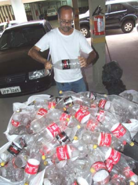 Luiz Pires mostra as garrafas que foram doadas para a confecção de móveis pet