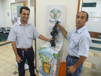 Nicolau Fahd (E) e José Ribamar Batista entregam  produtos recicláveis ao Programa Papa-Pilhas