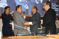 Deputado Pavão Filho entrega a medalha ao Des. Gerson de Oliveira, observado pelo presidente da Assembleia, Marcelo Tavares. 