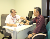 O médico Luís Carlos afere a pressão arterial do servidor Alexandre Pires, da Secretaria do Pleno.