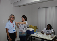 Márcia de Sousa, terceirizada lotada na Seção de Saúde, recebendo dose da vacina, aplicada por Elenaide