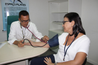 Cardiologista Ércio aferindo a pressão arterial da servidora Márcia Belfort