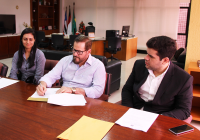 Carlos Adler assina o contrato observado pelo superintendente da SPU, Rafael Ribeiro, e pela corretora da Imobiliária Kenard Imóveis, Bruna Amorim.