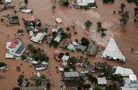 Foto aérea de casas inundadas pela enchente na região do Vale do Taquari, no Rio Grande do Sul. Na imagem também há várias árvores.