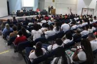 Foto mostra o auditório juiz Ari Rocha cheio de pessoas. Ao fundo, autoridades convidadas para palestrar no Fórum Caminhos da Liberdade sentadas diante do público.