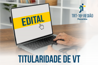 Foto de mãos digitando em um notebook, em cuja tela se lê a palavra EDITAL em letras azuis escuras sobre uma tarja amarela centralizada. Na base, também em letras azuis escuras, lê-se TITULARIDADE DE VT.