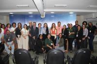 Foto mostra um grupo de pessoas formado por homens e mulheres. Todos estão no auditório da Ejud-16