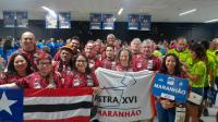 Foto mostra um grupo formado por homens e mulheres reunidos. No primeiro detalhe das bandeiras do estado do Maranhão, da ASTRA XVI e uma placa com o no Maranhão.