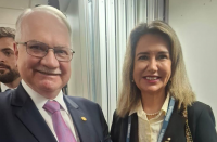 Foto mostra um homem e uma mulher, os dois estão em pé um ao lado do outro