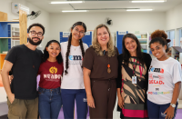 Foto mostra seis pessoas, uma ao lado da outra, em pé, dentro de uma sala de aula. Alguns são estudantes com o uniforme do IEMA