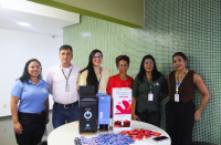 Foto mostra um grupo de pessoas em pé um ao lado do outro.