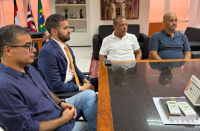 Foto mostra em destaque quatro pessoas sentadas à mesa