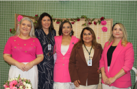 Foto mostra cinco mulheres em pé, uma ao lado da outra. 