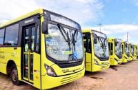 Foto mostra ônibus parados em uma garagem.