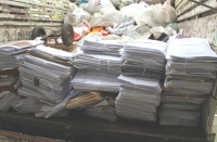Foto mostra várias pilhas de papel colocada na carroceria de uma caminhão
