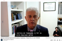 Foto mostra um homem sentado e posicionado no centro da foto.