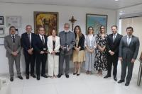 Foto mostra um grupo de pessoas em pé, um ao lado do outro.