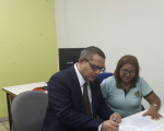 O presidente do TRT-MA assina o Termo de Doação, observado pela representante COOPRESL, Maria José de Castro