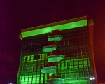 fachada do prédio-sede iluminada de verde durante este mês