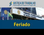 Arte com foto da fachada do prédio-sede do TRT16, mostrando bandeiras hasteadas do Brasil, do Maranhão e do Tribunal à esquerda. Abaixo, texto Feriado na cor amarela sobre faixa azul. 