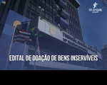 Fachada do prédio-sede do TRT16 com bandeiras hasteadas do Brasil, do Maranhão e do Tribunal. Abaixo, texto Edital de Doação de Bens Inservíveis na cor branca. No canto superior à direita, logomarca do Tribunal na cor branca.