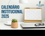 Imagem de uma calendário de mesa à frente de um notebook fechado e ao lado de uma lumiária branca e de um vaso com planta verde. Em primeiro plano, o texto CALENDÁRIO INSTITUCIONAL 2025 em letras azuis. No canto superior direito, logomarca do TRT-16.