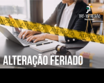 Recorte da foto de um homem, usando terno escuro e camisa social branca, digitando em um notebook que está sobre uma mesa. Em primeiro plano, faixa amarela na diagonal, onde se lê ATENÇÃO. No canto superior direito, logomarca do TRT-16 e no canto inferior esquerdo, texto escrito na cor branca ALTERAÇÃO FERIADO.