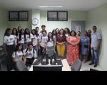 Foto mostra estudantes e professores do IEMA Itaqui-Bacanga ao lado da juíza Carolina Burlamaqui em uma sala de audiências no Fórum Astolfo Serra.