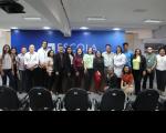 Foto mostra servidores, terceirizados e a palestrante enfermeira Marília de Almeida. Todos em pé no auditório da Ejud16