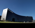 Foto da fachada do TST à distância com céu azul ao fundo.