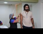 Foto mostra duas pessoas. Uma mulher aplicando uma vacina no braço direito de um homem durante a campanha da Semana de Saúde do TRT16 (Maranhão)