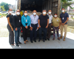 Foto de servidores posicionados diante de um caminhão carregado de processos antigos descartados para reciclagem