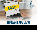 Foto de mãos digitando em um notebook, em cuja tela se lê a palavra EDITAL em letras azuis escuras sobre uma tarja amarela centralizada. Na base, também em letras azuis escuras, lê-se TITULARIDADE DE VT.