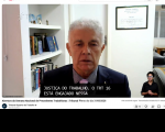 Foto mostra um homem sentado e posicionado no centro da foto.