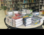 Foto mostra vários livros posicionados sobre uma mesa.