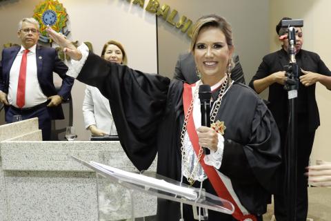 muhler de toga com o braço estendido prestando juramento