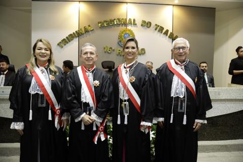 duas mulheres e dois homens vestidos de toga pousando para foto em pé