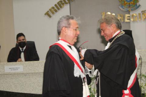 dois homens de toga em pé, um de frente para o outro, no ato de entrega de medalha