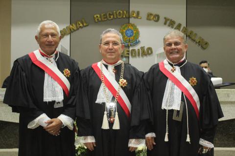 três homens de toga pousando para foto