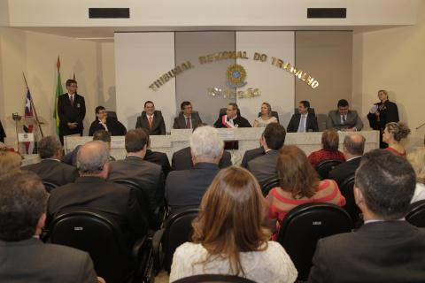 pessoas sentadas em frente a uma mesa de honra com várias autoridades
