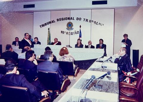 pessoas em frente a uma mesa de honra, sentadas, com várias autoridades